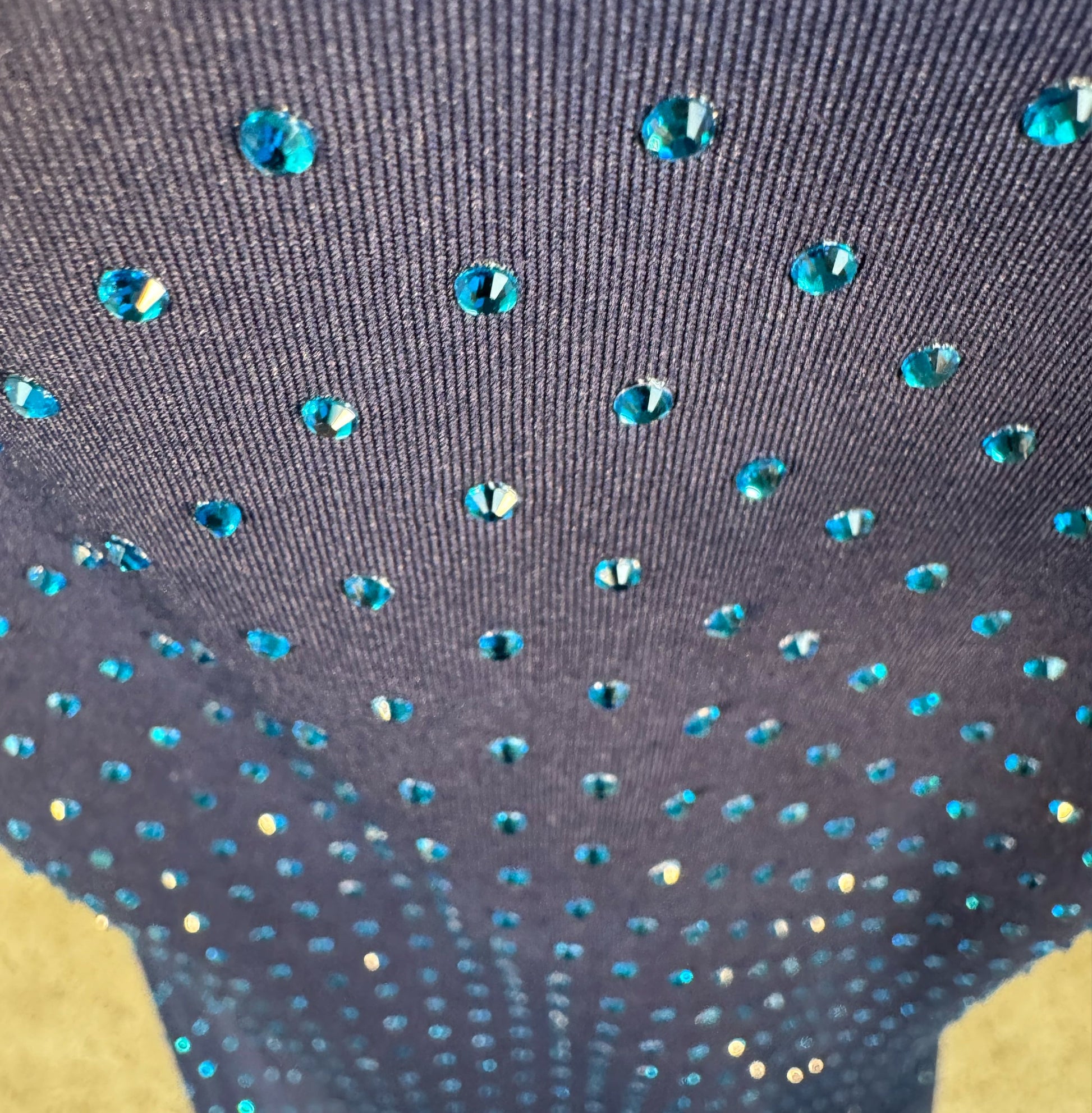 Looking down at Capri Blue Crystals on Navy Fabric Dotted T-shirt showing a close up of the rhinestone grid pattern and the sparkles as your focus shifts.