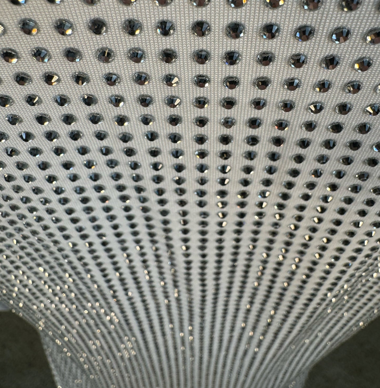 Looking down at Clear Crystals on White Fabric T-shirt showing a close up of the rhinestone grid pattern and the sparkles as your focus shifts.